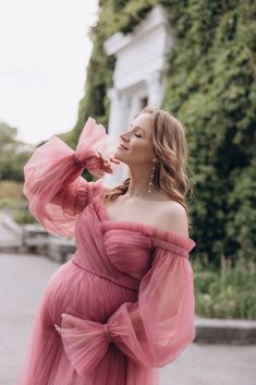 a woman in a pink dress standing on the street