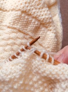 someone is knitting the stitches on their sweater