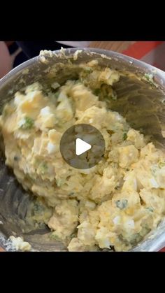 a metal bowl filled with mashed potatoes on top of a table