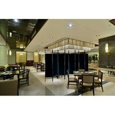 an empty restaurant with tables and chairs in front of a wall that has glass partitions