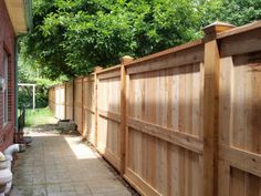 a wooden fence next to a brick building