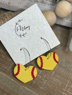 two yellow and red earrings sitting on top of a wooden table next to some eggs