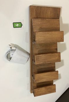 a toilet paper dispenser next to a wooden shelf