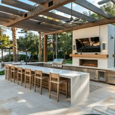 an outdoor kitchen with grill and seating area