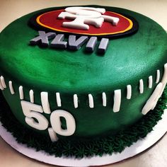 a green cake with the number 50 on it and an image of a football helmet