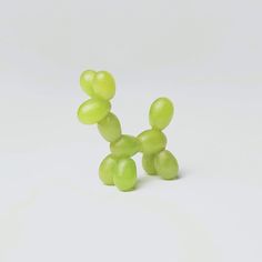 a small green balloon dog on a white surface