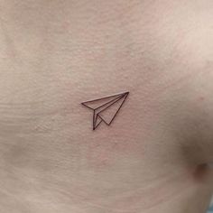 a small paper airplane tattoo on the stomach