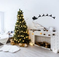 a decorated christmas tree in front of a fireplace with presents on the floor next to it