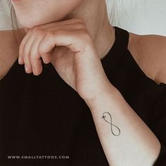 a woman with a small tattoo on her left arm and the word love is written in cursive font