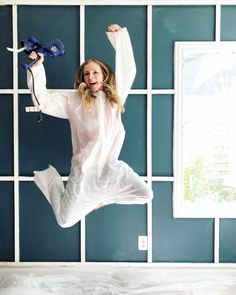 a woman jumping in the air while holding a hair dryer