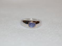 Our natural tanzanite cabochon ring set in silver with gold accents is simple and stylish. Created for anyone to wear and enjoy. 1.7ct oval tanzanite, sterling silver, size 11.5, inquire for other sizes Unique Birthstone Rings, Round Stone Ring, Mixed Metal Ring, Tanzanite Ring, Purple Band, Cabochon Ring