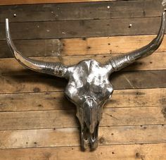 a bull's skull mounted on the side of a wooden wall