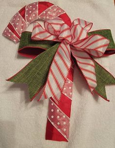 a red and white christmas bow with polka dots on it sitting on a towel in the bathroom