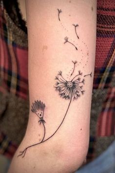 a dandelion tattoo on the arm