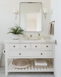 a white bathroom with a sink and mirror