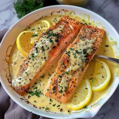 two salmon fillets with lemon sauce on a plate