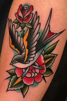 a tattoo with a bird and flowers on it