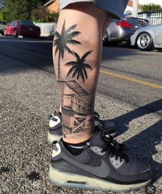 a person with a palm tree tattoo on their leg is standing in the middle of the street