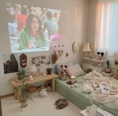 a bedroom with a bed, desk and large screen television on the wall above it