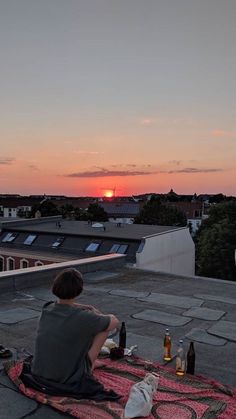 a person sitting on top of a roof next to bottles