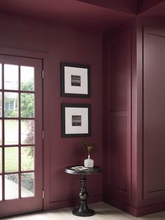 a room with red walls and two pictures on the wall