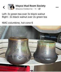 two gray vases sitting on top of a table