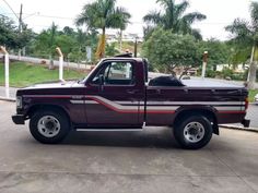 a maroon pickup truck parked in a driveway