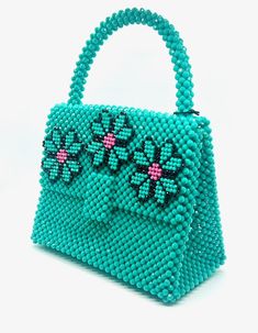 You'll feel lucky to have this bag from Del Duca. Handmade in Argentina, this beaded bag boasts a vibrant green color and three flowers with pink accents along the top flap. This chic bag comes with a red insert to ensure all your goods stay safe. Plastic beads 8.25" L x 4.25" W x 11" H Green Flower-shaped Shoulder Bag For Daily Use, Green Flower Shaped Shoulder Bag For Daily Use, Green Floral Shoulder Bag For Daily Use, Green Floral Shoulder Bag For Everyday Use, Green Handheld Bag For Gifts, Green Handheld Bag For Gift, Green Flower-shaped Everyday Bags, Green Handheld Box Bag With Removable Pouch, Green Rectangular Box Bag With Top Carry Handle