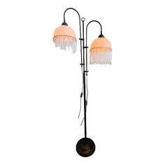 an old fashioned floor lamp with two lights on each side and one light on the other