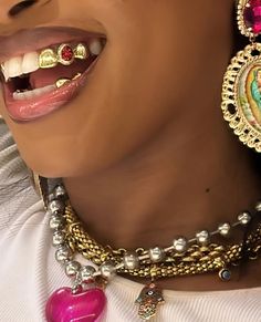 a close up of a person wearing necklaces and earrings on their neck with an open mouth