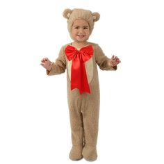 a little boy dressed in a teddy bear costume with a red bow on his head