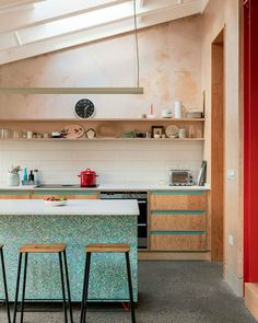 a kitchen with two stools next to a counter