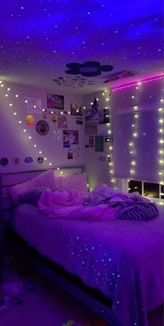 a bedroom with purple and blue lights on the ceiling, bed in front of it