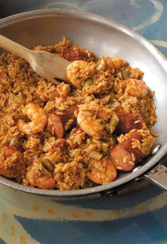 a pan filled with shrimp and rice on top of a table