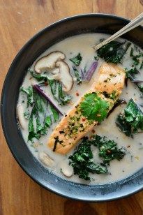 a black bowl filled with broccoli and fish