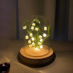 a glass dome with flowers in it sitting on a table