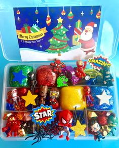 a plastic container filled with assorted christmas ornaments and toys in front of a blue background