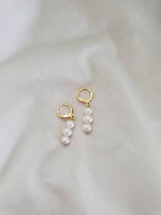 These freshwater pearl huggies are the perfect touch of elegance for any occasion. Both standard and clip on huggie hoops are available, all hypoallergenic and nickel free. Standard gold hoops are hypoallergenic and nickel free (18 karat gold plated). Standard silver hoops are hypoallergenic and nickel free (platinum plated). Clip on gold hoops are hypoallergenic and nickel free (18 karat gold plated). Clip on silver hoops are hypoallergenic and nickel free (platinum plated). Please feel free to Everyday Pearl Drop Dangle Huggie Earrings, Pearl White Dangle Hoop Earrings With Pearl Charm, Delicate Huggie Pearl Earrings, Dainty Pearl Dangle Hoop Earrings, Minimalist Pearl Dangle Huggie Earrings, Pearl Drop Dangle Hoop Earrings, White Pearl Huggie Earrings In Dainty Style, Minimalist Pearl Huggie Earrings As A Gift, White Pearl Charm Dangle Huggie Earrings