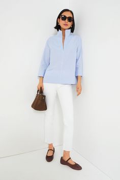 Your staple style gets a fresh update with the Sullivan Blouse. Made from a lightweight and crisp cotton material that provides effortless polish with a classic blue pinstripe print that pairs well with all kinds of neutrals, this stand collared shirt is a must-have in any closet. Style it with denim and sneakers for off-duty weekend wear, under a cardigan with boots when the temps drop, or with a sweet skirt and ballet flats for feminine flair. Stand collar V-neckline Bracelet length sleeves wi Modern Spring Business Casual Blouse, Modern Business Casual Spring Blouse, Spring Office Blouse With Striped Collar, Spring Business Casual Shirt With Striped Collar, Office Tops With Placket For Spring, Spring Split Neck Blouse With Placket, Spring Business Casual Top With Striped Collar, Spring Business Casual Tops With Striped Collar, Spring Office Tops With Striped Collar