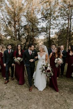 a group of people standing next to each other in front of some trees and grass