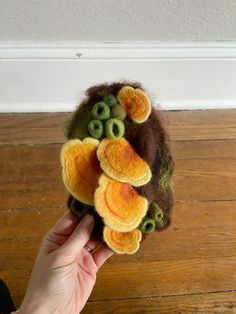 a hand holding a stuffed animal made from felt