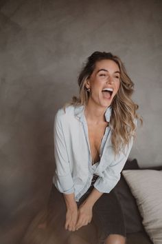 a woman sitting on top of a bed with her mouth open