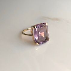 A 9 carat yellow gold Amethyst ring. This beautiful piece displays a gorgeous purple stone in the clutches of a striking gold setting. CONDITION: Minor wear can be seen on face. Condition consistent with age and use. Please see photos for more detail. STONE SIZE: 13mm x 15mm BAND WIDTH: 1mm SETTING HEIGHT: 5mm RING SIZE: UK: M | US: 6 1/4 WEIGHT: 4.2 grams Luxury Yellow Gold Amethyst Ring, Luxury Vintage Amethyst Ring, Luxury Yellow Gold Amethyst Ring With Accent Stones, Rectangular Amethyst Ring For Formal Occasions, Rectangular Amethyst Ring For Formal Events, Elegant Rectangular Amethyst Ring In Yellow Gold, Luxury Purple Amethyst Ring, Rectangular Shape, Luxury Purple Amethyst Rectangular Ring, Luxury Purple Rectangular Amethyst Ring