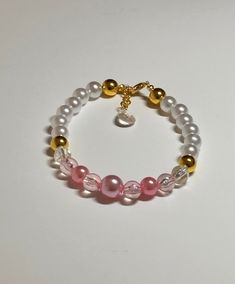 "This is an elegant OOAK handmade beaded bracelet. Very pretty pink/gold color with crystal accent beads on a stretchy elastic with dangle teardrop charm. Would fit a  7\" wrist or bigger.  The gold spacer beads accents make the crystal beads even prettier! Picture taken in different lighting to show how it looks under different settings. We offer free shipping on all of our items! If you are interested in a certain color combination, please send me a private message to see if we have your desir Gold Stretch Bracelet With 8mm Beads For Party, Elegant Pink Pearl Bracelet With 8mm Beads, Pink Beaded Round Pearl Bracelet, Handmade Pink Crystal Elegant Bracelet, Gold Crystal Bracelet With 8mm Beads For Party, Elegant Pink Bracelets With Gold Beads, Handmade Elegant Pink Crystal Bracelet, Elegant Handmade Pink Crystal Bracelet, Elegant Pink Hypoallergenic Bracelet