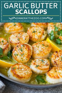 garlic butter scallops in a pan with lemon wedges