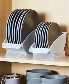 plates and cups are stacked on the shelf in front of each other, ready to be used