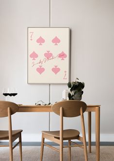 a table with two chairs and a painting on the wall