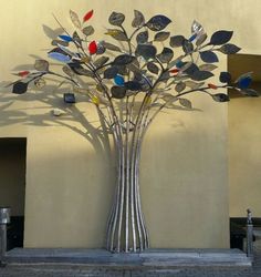 a metal tree with multi colored leaves on it