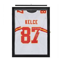 an autographed jersey hangs in a black framed display case with the name kelcee on it