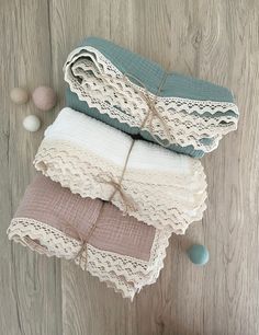 three pieces of lace sitting on top of each other next to some balls and yarn